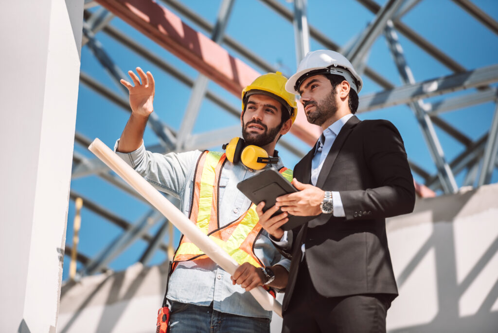 civil-engineer-construction-worker-manager-holding-digital-tablet-blueprints-talking-planing-about-construction-site-cooperation-teamwork-concept